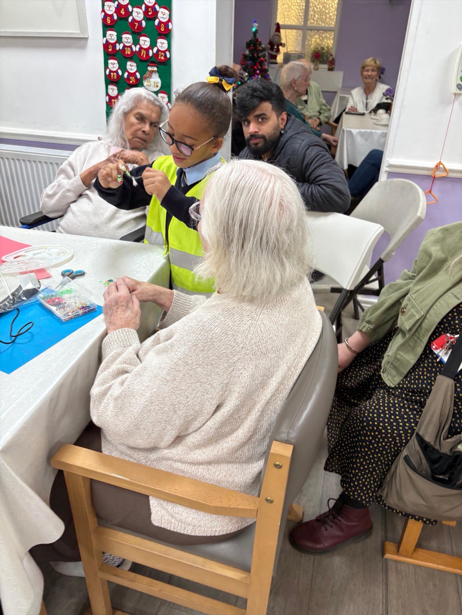 A St Boniface pupil helping a care-home resident with a Christmas craft